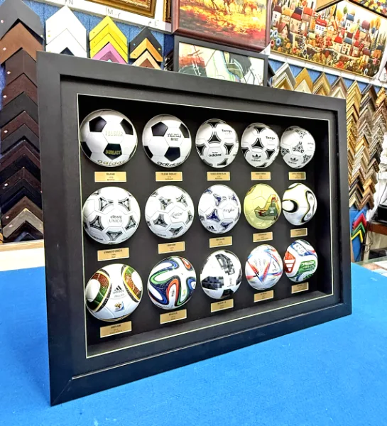 Custom football memorabilia display frame with collectible footballs and sports keepsakes