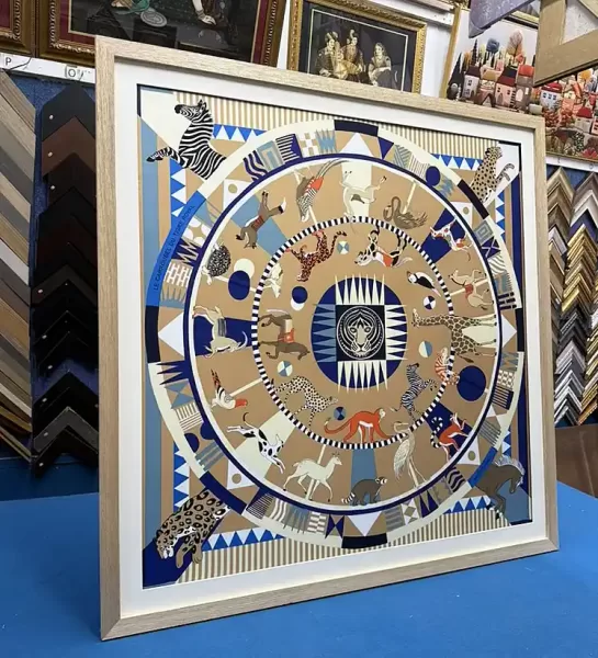 Decorative silk scarf professionally framed with a light wood frame and white matboard in Singapore.