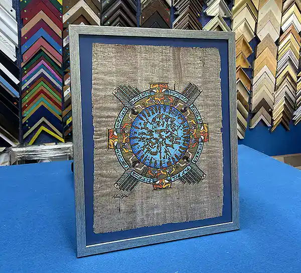 Egyptian papyrus artwork framed with a coloured background and custom wooden frame in Singapore.