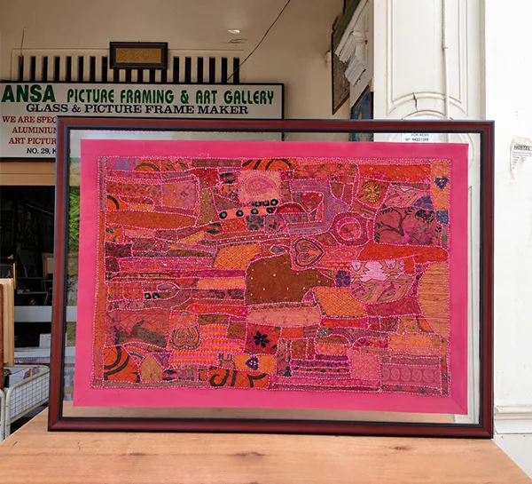 Double glass tapestry framing with a slim dark wood frame for handcrafted textile art in Singapore.
